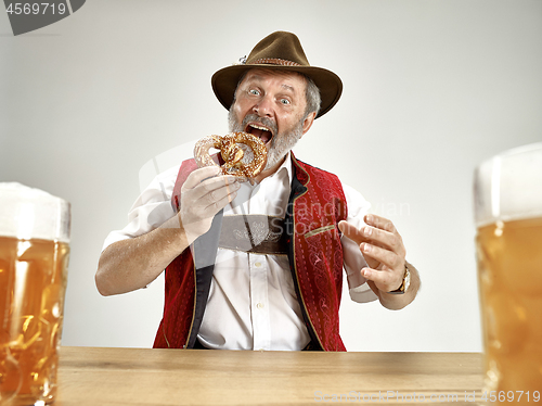 Image of Germany, Bavaria, Upper Bavaria, man with beer dressed in traditional Austrian or Bavarian costume