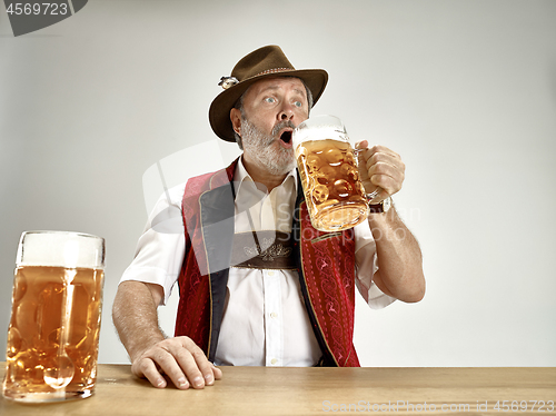 Image of Germany, Bavaria, Upper Bavaria, man with beer dressed in traditional Austrian or Bavarian costume