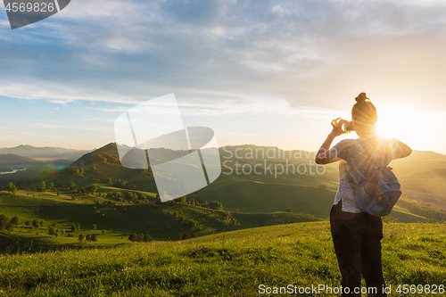 Image of Woman taking photo in mountain