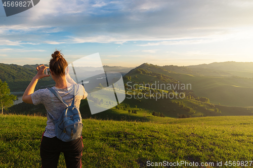 Image of Woman taking photo in mountain