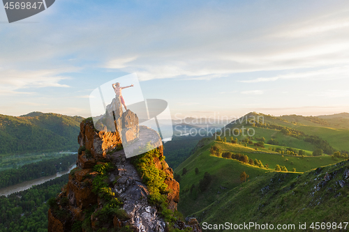 Image of Man standing on top of cliff