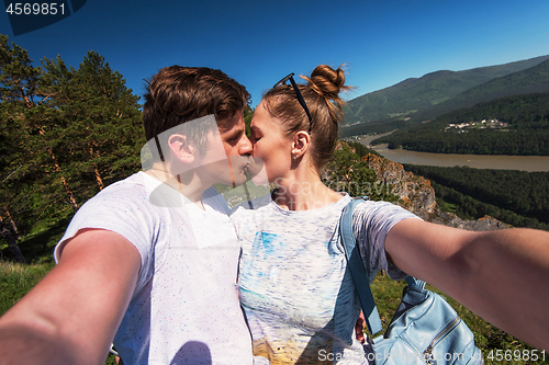 Image of Kissing man and woman on top mountain
