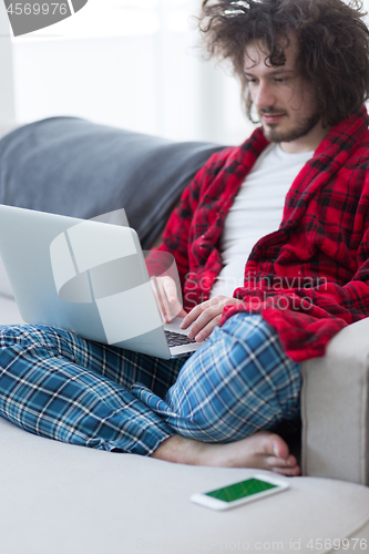 Image of man freelancer in bathrobe working from home