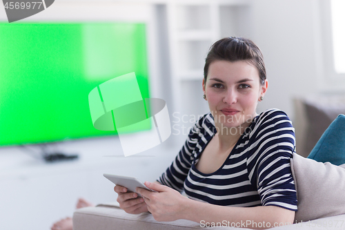 Image of woman on sofa using tablet computer