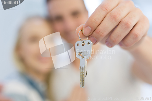 Image of couple showing a keys of their new house