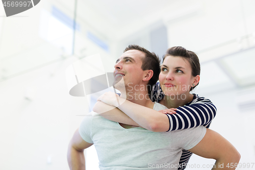 Image of handsome man piggybacking his girlfriend