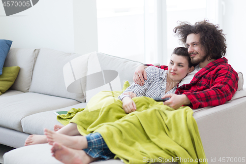 Image of Young couple on the sofa watching television