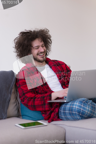 Image of man freelancer in bathrobe working from home