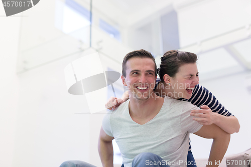 Image of handsome man piggybacking his girlfriend