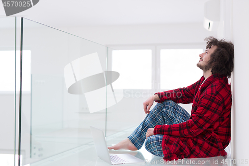 Image of young freelancer in bathrobe working from home