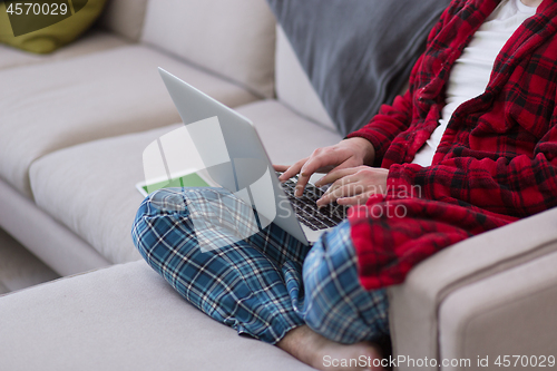 Image of man freelancer in bathrobe working from home