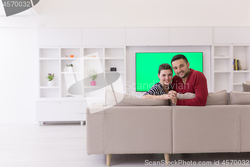 Image of couple hugging and relaxing on sofa