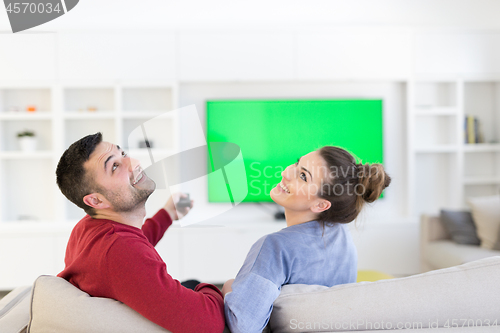 Image of Young couple on the sofa watching television