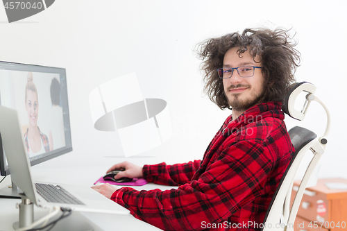 Image of graphic designer in bathrobe working at home