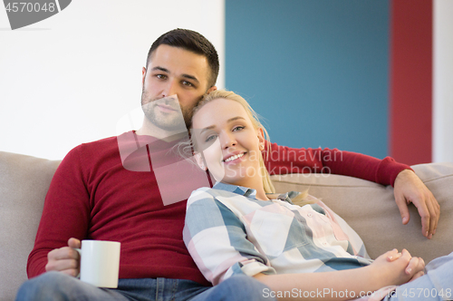 Image of couple hugging and relaxing on sofa