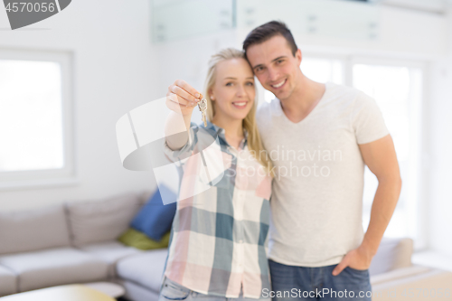 Image of couple showing a keys of their new house