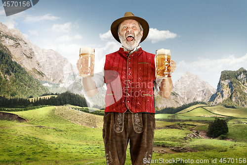 Image of Germany, Bavaria, Upper Bavaria, man with beer dressed in traditional Austrian or Bavarian costume