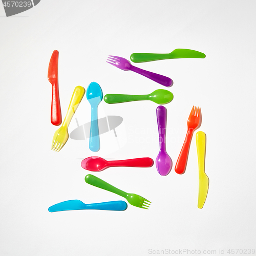 Image of Colorful pattern from plastic eating utensil on a grey background.