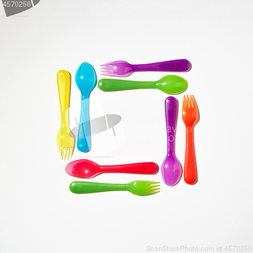 Image of Square from colorful plastic cutlery on a light background.