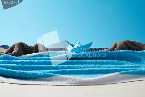 Image of Seashore made from colored terry towels on doutone paper background.