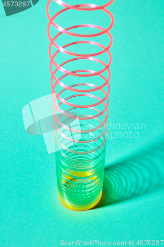 Image of Stretching plastic colored spring with shadows shadows