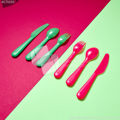 Image of Kids plastic colorful cutlery on a duotone background.