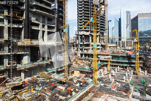 Image of Laborers working on modern constraction site works in Dubai. Fast urban development consept