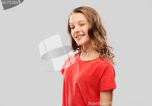 Image of smiling teenage girl in red t-shirt winking