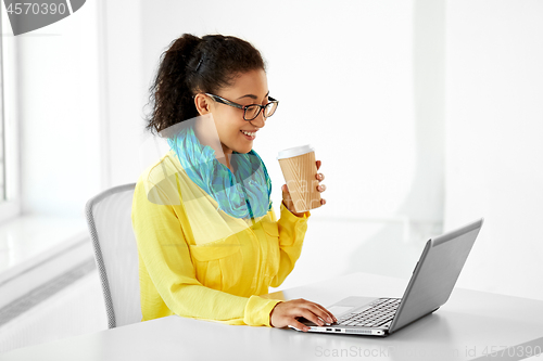 Image of creative woman with coffee and laptop at office