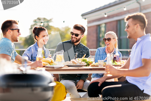 Image of happy friends having bbq party on rooftop