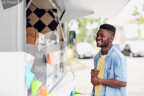 Image of male customer looking at billboard at food truck