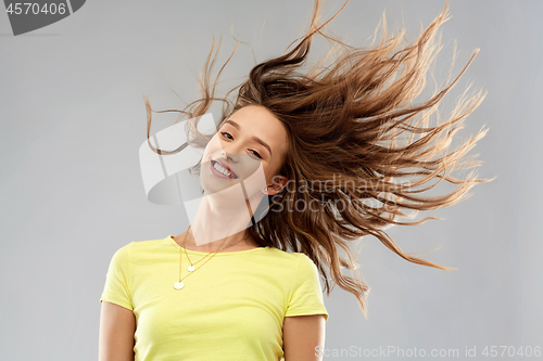 Image of happy young woman with waving long hair