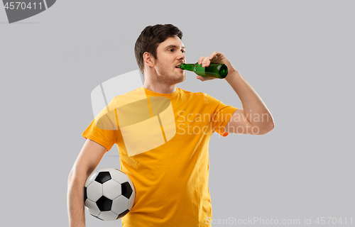 Image of man or football fan with soccer ball drinking beer