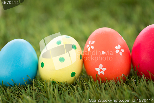 Image of row of colored easter eggs on artificial grass