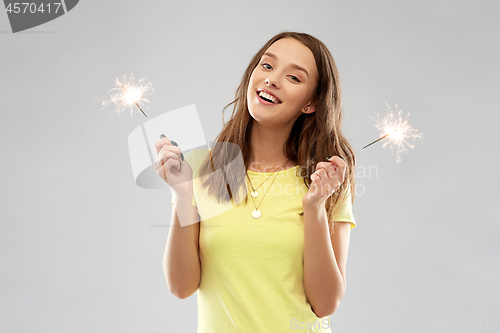 Image of happy teenage girl with two sparklers