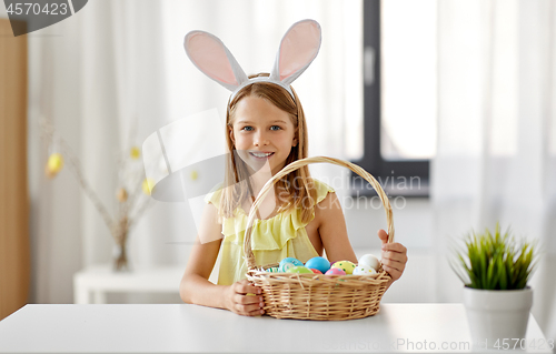 Image of happy girl with colored easter eggs at home