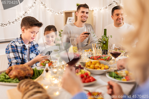 Image of children with smartphone at family dinner party