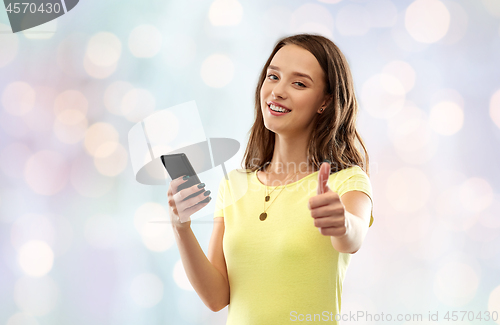 Image of teenage girl with smartphone showing thumbs up