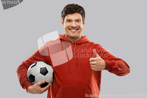 Image of male football fan with soccer ball shows thumbs up