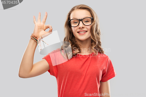 Image of smiling student girl in glasses showing ok sign