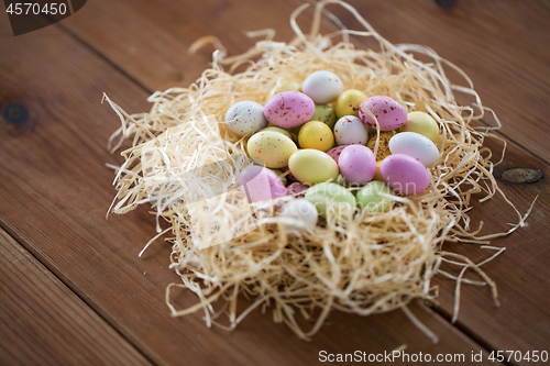 Image of easter eggs in straw nest on wooden table