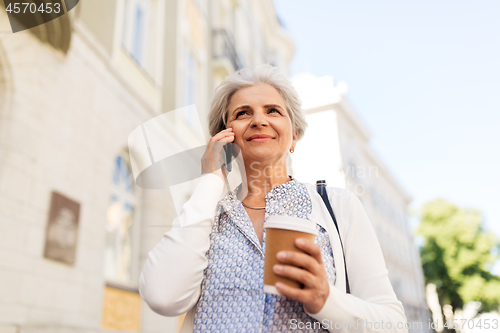 Image of senior woman calling on smartphone in city