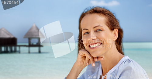 Image of portrait of happy smiling woman on summer beach