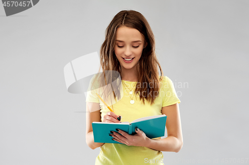 Image of teenage student girl writing to diary or notebook