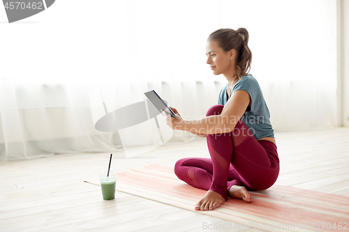 Image of woman with tablet pc and drink at yoga studio