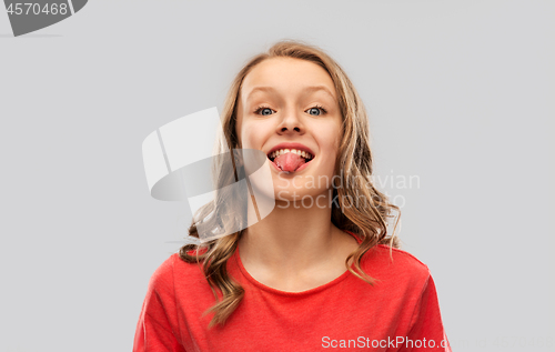 Image of funny teenage girl in red t-shirt showing tongue