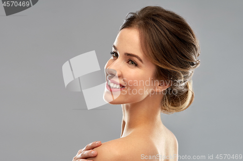 Image of smiling young woman over grey background