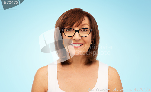 Image of portrait of senior woman in glasses over white