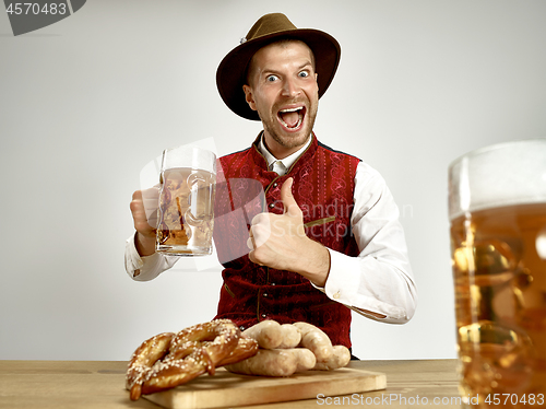 Image of Germany, Bavaria, Upper Bavaria, man with beer dressed in traditional Austrian or Bavarian costume