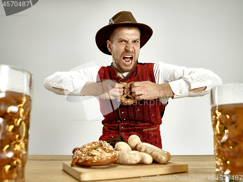 Image of Germany, Bavaria, Upper Bavaria, man with beer dressed in traditional Austrian or Bavarian costume